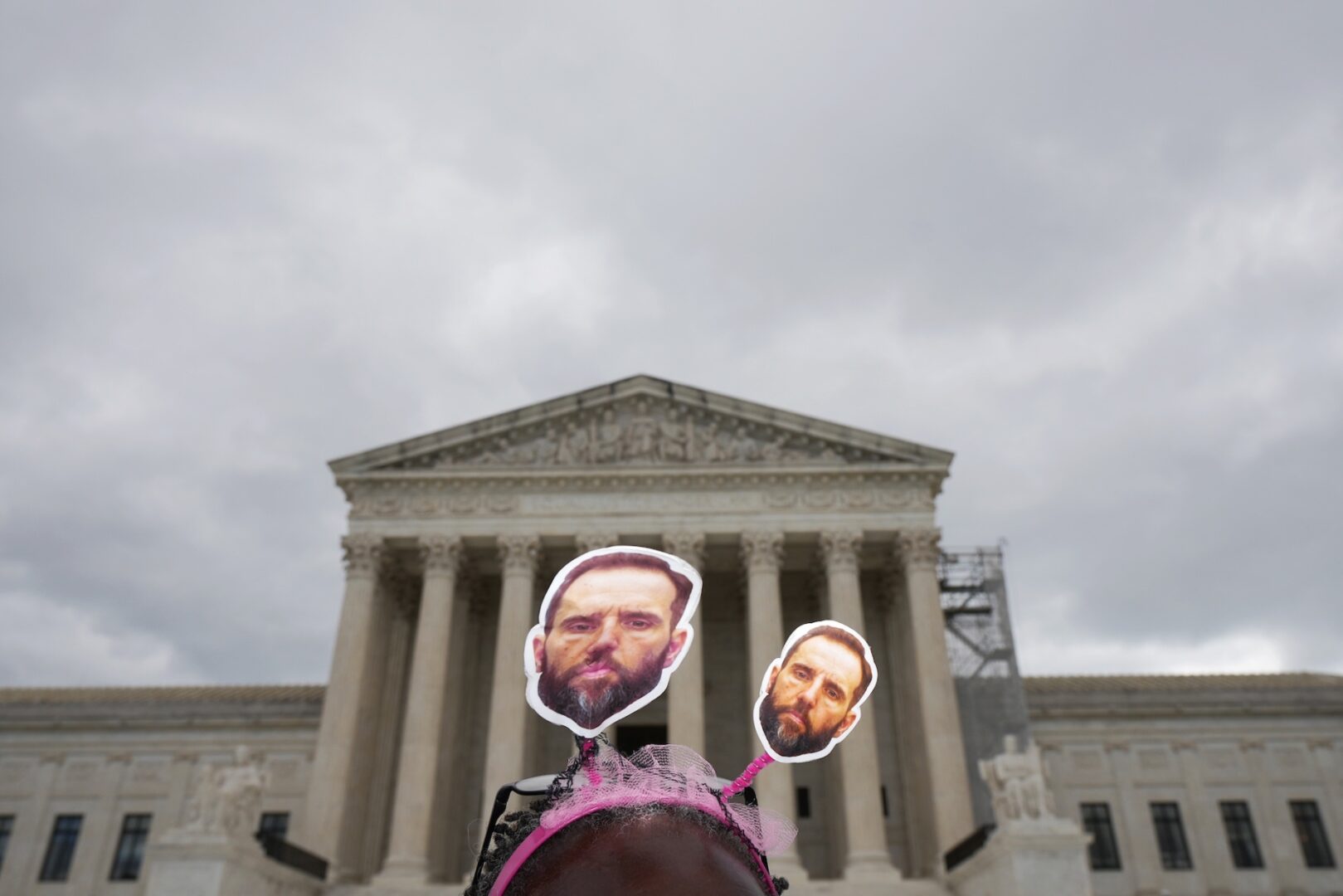 A protester wears a head band adorned with the face of Special Counsel John L. “Jack” Smith in front of the Supreme Court on Monday.