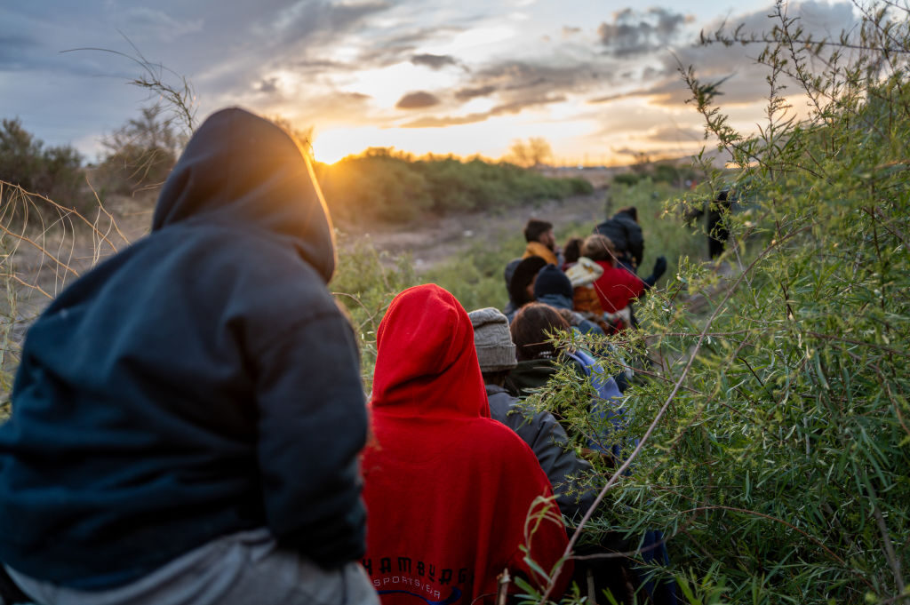 Migrants from Peru and Venezuela walk down a trail on the U.S. side of the Rio Grande river Tuesday in El Paso, Texas. 