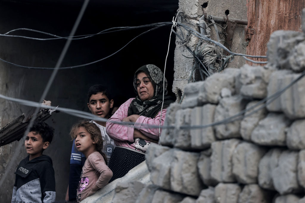 Palestinians watch Tuesday the transfer of bodies of people killed in an overnight bombardment that targeted a residential area in Rafah, Gaza. 