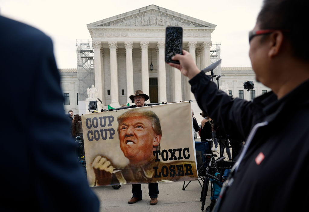 A demonstrator participates in a protest outside the Supreme Court on Thursday, when the justices hear oral arguments in a case about presidential immunity from prosecution.