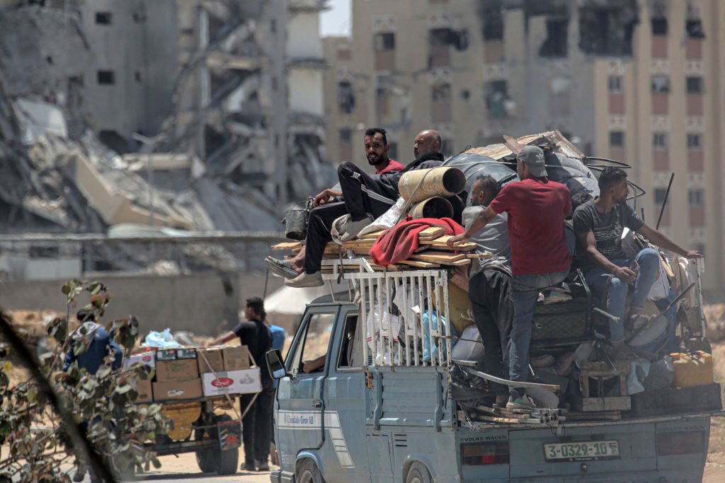 Palestinians who fled Rafah in the southern Gaza Strip transport their belongings in the back of a truck as they arrive to take shelter in Khan Yunis on Sunday.