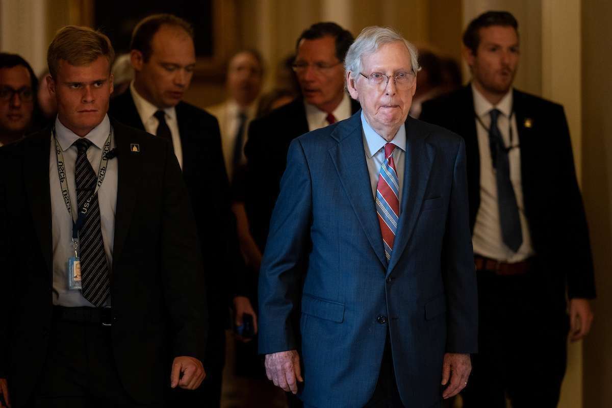 Senate Minority Leader Mitch McConnell, R-Ky., walks back to his office escorted by staff, security and Sen. John Barrasso, R-Wyo., after the Senate Republicans’ news conference in the Ohio Clock Corridor in the Capitol on July 26. 