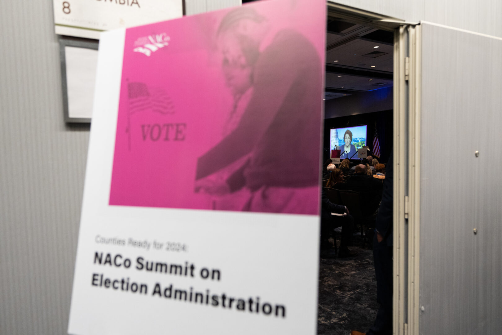 Sen. Amy Klobuchar, D-Minn., speaks via video feed to a crowd of local officials at the National Association of Counties legislative conference in Washington on Monday. 