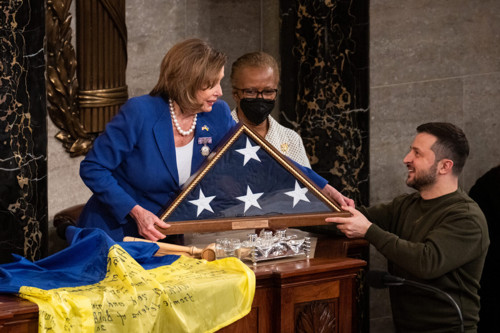 Ukrainian President Volodymyr Zelenskyy exchanges flags with House Speaker Nancy Pelosi, D-Calif., at the end of his address to a joint meeting of Congress in the Capitol on Dec. 21, 2022.